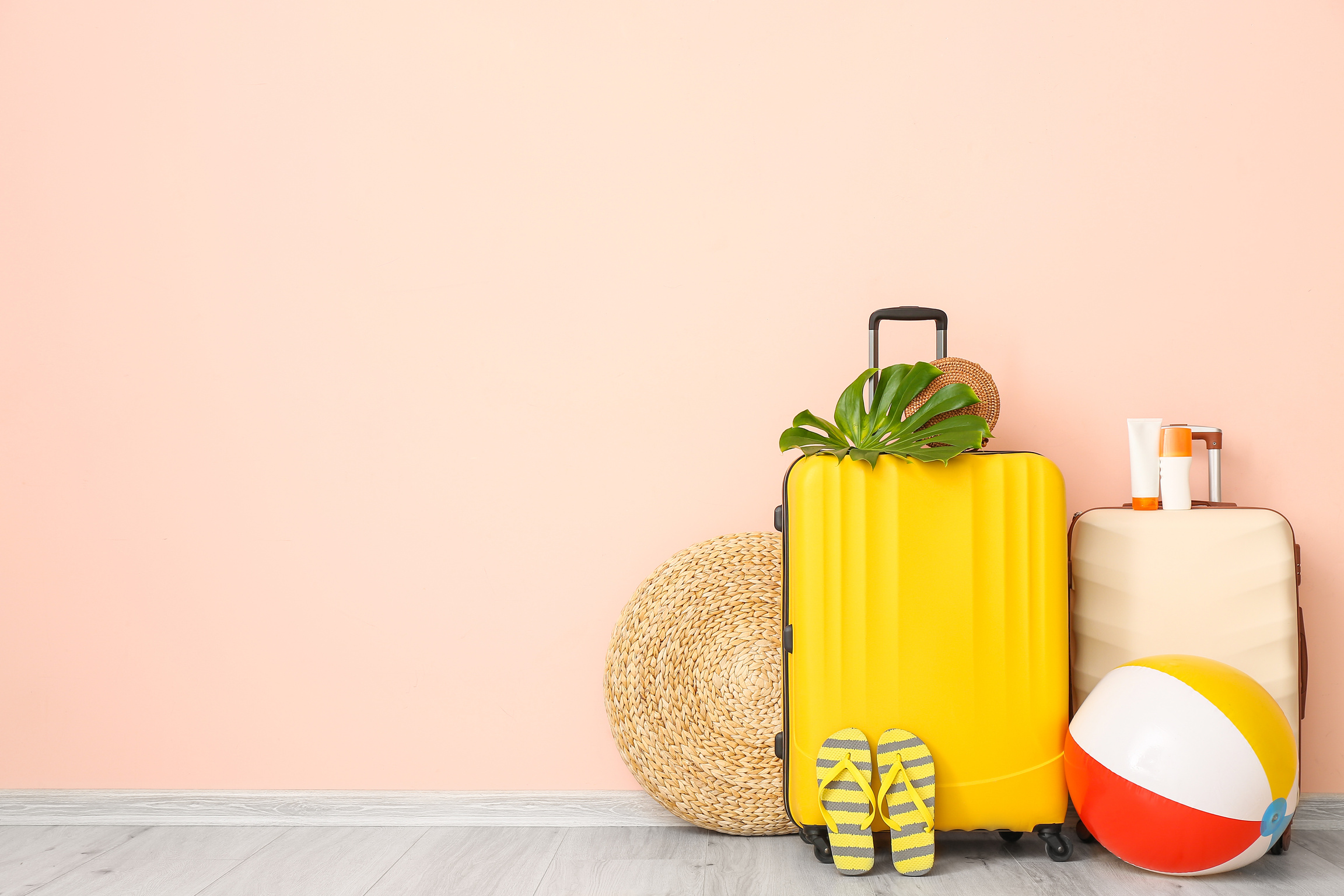 Packed Suitcases for Summer Travel near Pink Wall